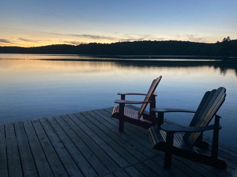 brown wooden bench on dock near lake during daytime