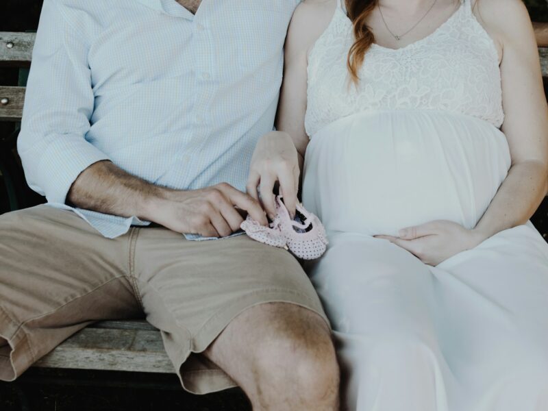 close-up photo of man and woman sitting on bench