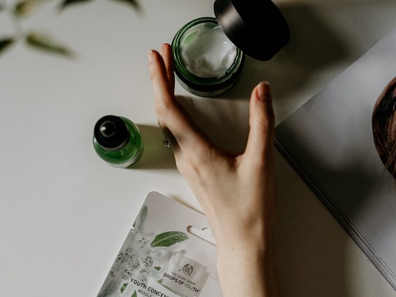 person touching black plastic bottle