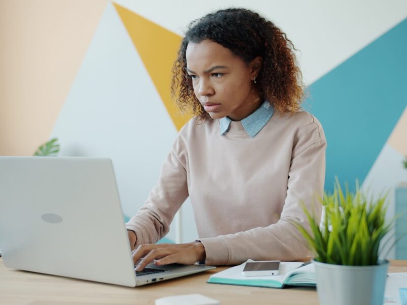 Young woman concentrating while working on a laptop.